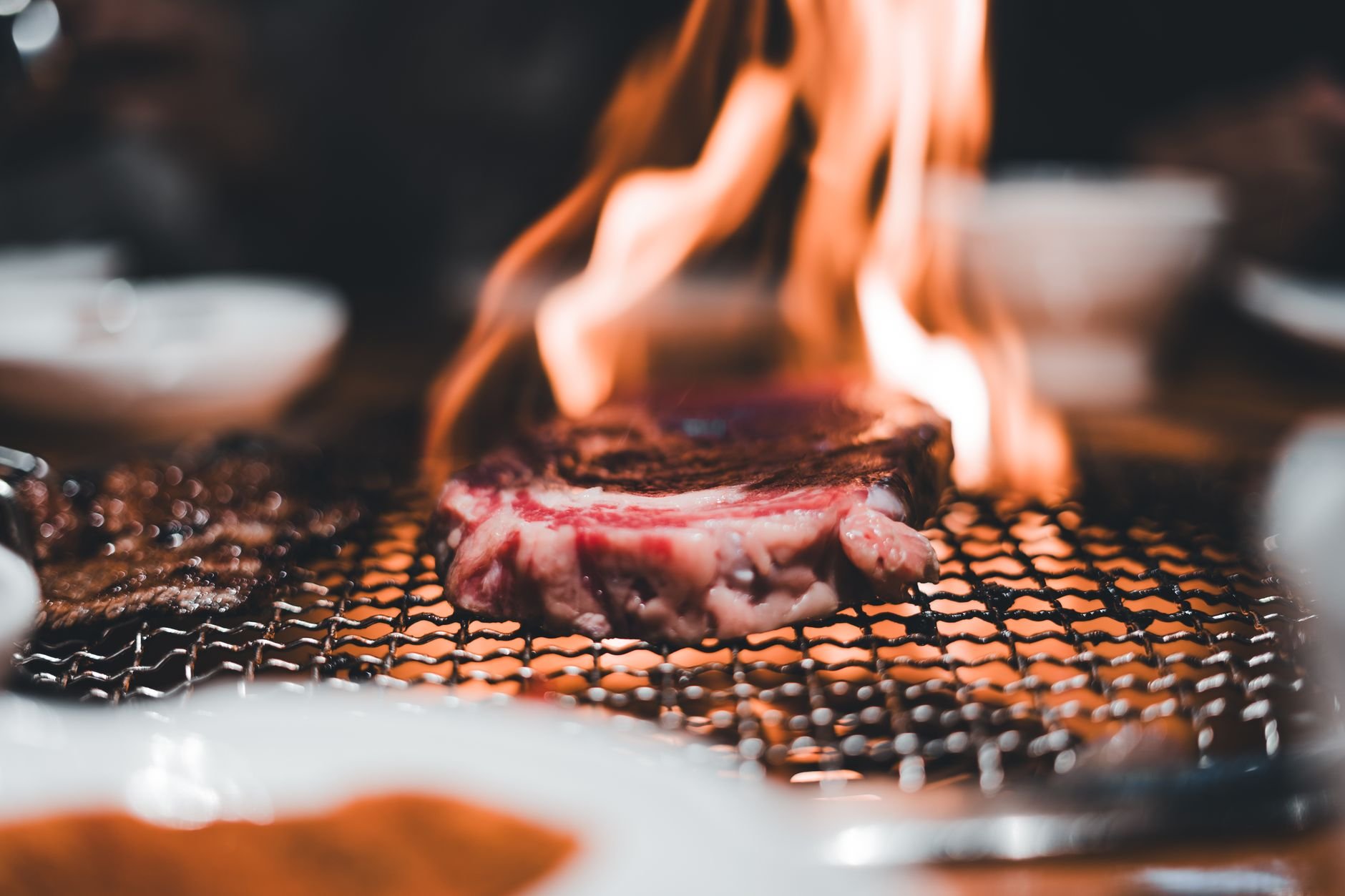 Beef grilled on charcoal BBQ with visible flames